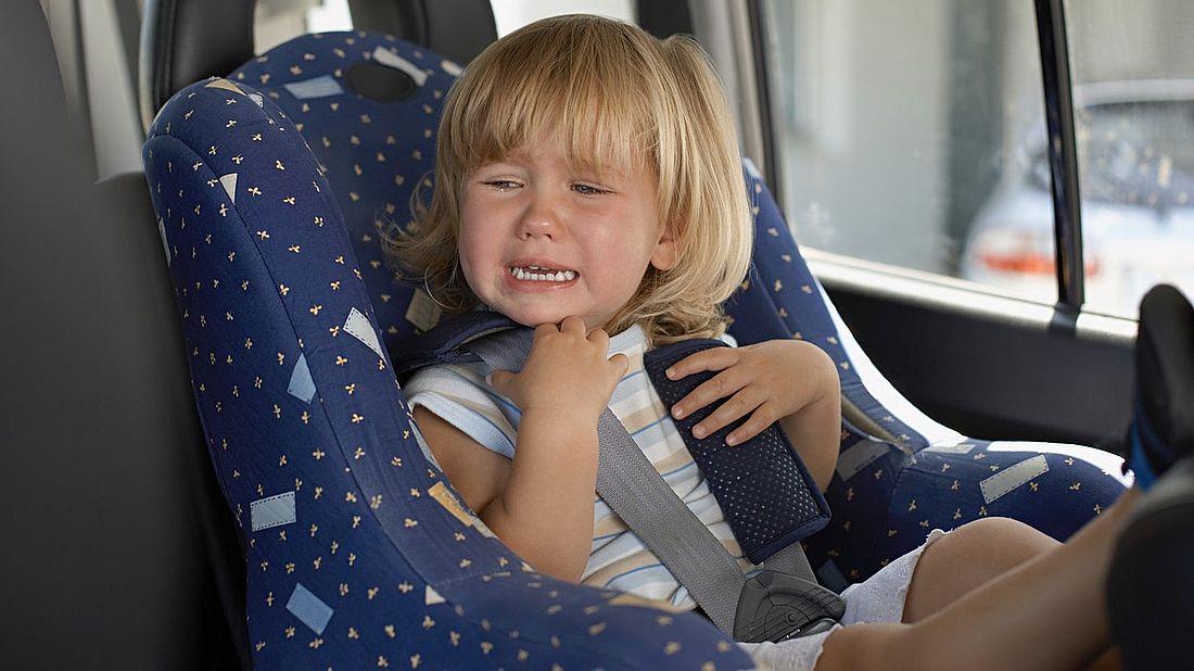 Young girl crying in her car seat